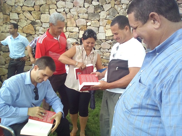 El autor dedica los libros luego de la presentación// Fotos Eliexer Peláez