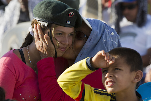 Tatiana, a rebel of the Revolutionary Armed Forces of Colombia, FARC, is kissed by her grandmother during an event organized by  the FARC in the Yari Plains of southern Colombia, as they watch live images of government and FARC leaders signing a peace agreement in Cartagena to end more than five decades of conflict, Monday, Sept. 26, 2016. (AP Photo/Ricardo Mazalan)