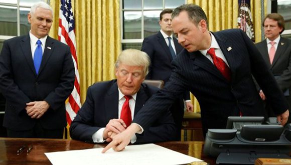 El momento en el que el presidente de Estados Unidos, Donald Trump, firma una de sus primeras órdenes ejecutivas. Foto: Reuters.
