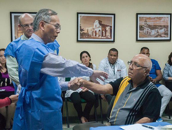 El Dr. Daniel Truong, Presidente del Instituto de Parkinson y Desórdenes del Movimiento, realiza reconocimiento de paciente con distonia de la mano de consulta externa, en el CIREN. Foto: ACN.