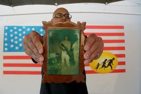 El veterano de guerra Ivan Ocon exhibe una foto de combate en un centro para los veteranos mexicanos deportados en Ciudad Juárez, el 19 de abril de 2017. Foto: AFP.