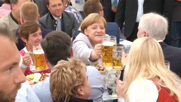 La canciller alemana Angela Merkel alza su tarro de cerveza durante una campaña electoral de su Unión Demócrata Cristiana y la Unión Social Cristiana, en Munich. Foto: AP.