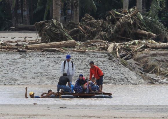 Un grupo de personas se pone a salvo de las riadas provocadas por la tormenta Tembin en Filipinas. Foto: Reuters.