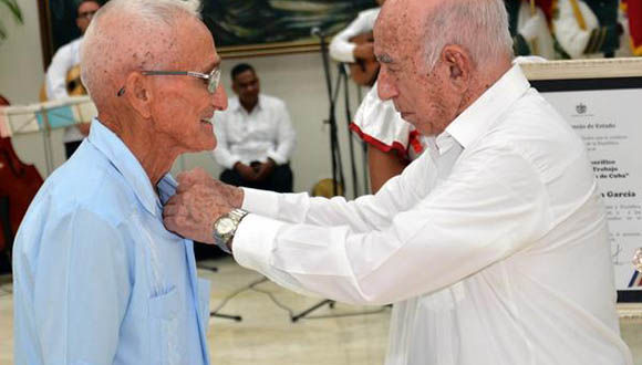 José Ramón Machado Ventura (D), Segundo Secretario del Partido Comunista de Cuba, condecora con el título de Héroe del Trabajo de la República de Cuba, al campesino Luis Rogelio Batista García, del municipio de San Luis, de Santiago de Cuba. Foto: Marcelino Vázquez Hernández/ ACN. 