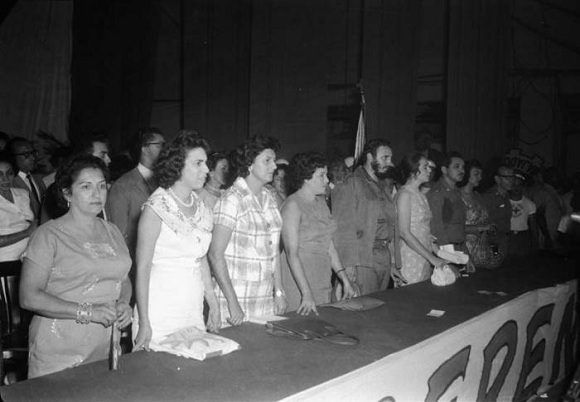 Fidel Castro junto a Vilma Espín y Gilberto Cervantes, presidente de la Cruz Roja Cubana, en el acto de fundación de la Federación de Mujeres Cubanas (FMC) en el teatro Lázaro Peña en La Habana, 23 de agosto de 1960. Foto: Tirso Martínez / Sitio Fidel Soldado de las Ideas