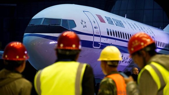 Un grupo de trabajadores frente a un Boeing 737 Max 8 de Air China. Foto: Thomas Peter/ Reuters