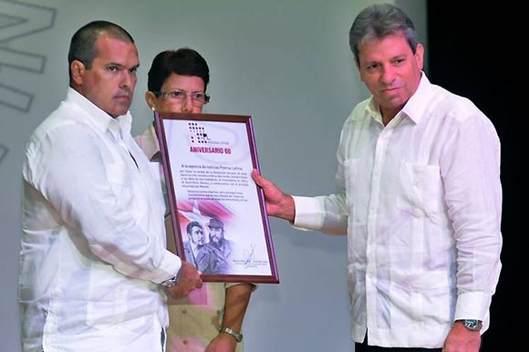 Luis Enrique González, presidente de Prensa Latina, recibe el reconocimiento firmado por Miguel Diaz Canel de manos de Víctor Gaute, miembro del Secretariado del CC.PCC, en el acto por el aniversario 60 de Prensa Latina // Foto: Prensa Latina