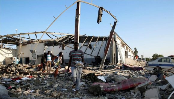 Inmigrantes recogen lo que queda de sus pertenencias tras el ataque aéreo sufrido en Trípoli. Foto: Ismail Zitouny/ Reuters.