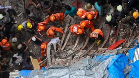 Un grupo de rescatistas trabaja en un edificio derrumbado por las lluvias del Monzón en Bombay (India). Foto: EFE.