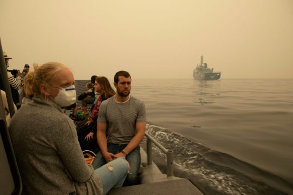 Varias personas evacuadas de Mallacoota, en Australia, por la marina australiana. Foto: Shane Cameron/AFP.