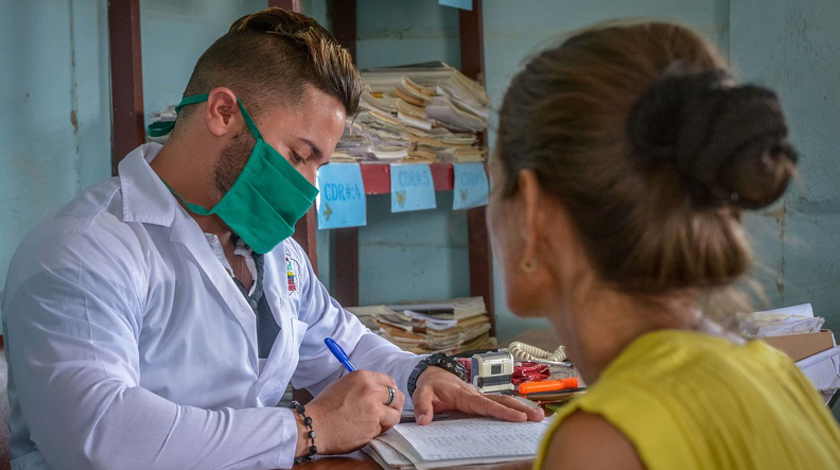 El doctor Oscar Mantecón Aguilera (I), uno de los dos especialistas en medicina general integral que laboran en el Consultorio Médico de Urgencia, en la comunidad de Becerra, aproximadamente a ocho kilómetros de esta ciudad, monitorea que se cumplan las medidas sanitarias para evitar el contagio con el coronavirus, Las Tunas, Cuba, el 19 de marzo del 2020. ACN FOTO/Yaciel PEÑA DE LA PEÑA/dir
