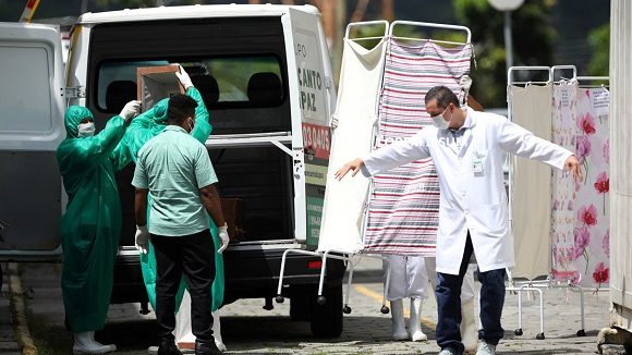 Empleados de tanatorios con trajes protecrores en Manaus, Brasil, el 17 de abril de 2020. Bruno Kelly / Reuters.