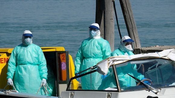 Personal sanitario se dirige en una lancha ambulancia a un hospital de Venecia, Italia. Foto: Manuel Silvestri / Reuters.