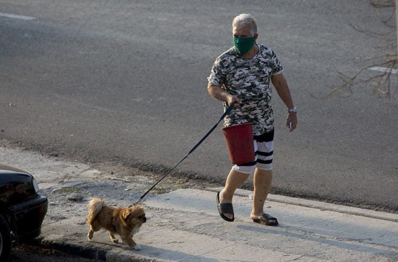 Bajando la basura y sacando el perrito hacer pipi con nasobuco. Foto: Ismael Francisco/ Cubadebate.