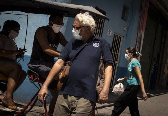 Personas caminan en calles de la Vieja Habana usando cubrebocas, como medida sanitaria ante el Covid-19. Foto: AP.