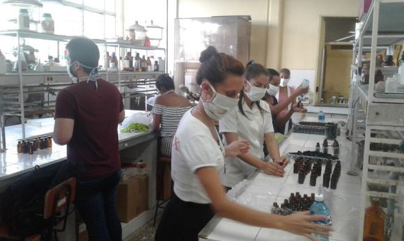 Estudiantes y profesores de la UH participan en llenado y etiquetado de frascos de hipoclorito de sodio. Foto: Odalis Fundora/Facebook.