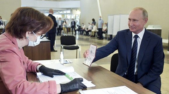 El presidente ruso Vladimir Putin muestra su pasaporte a una trabajadora electoral poco antes de votar en Moscú, el miércoles 1 de julio de 2020. Foto: Alexei Druzhinin / Sputnik / AP