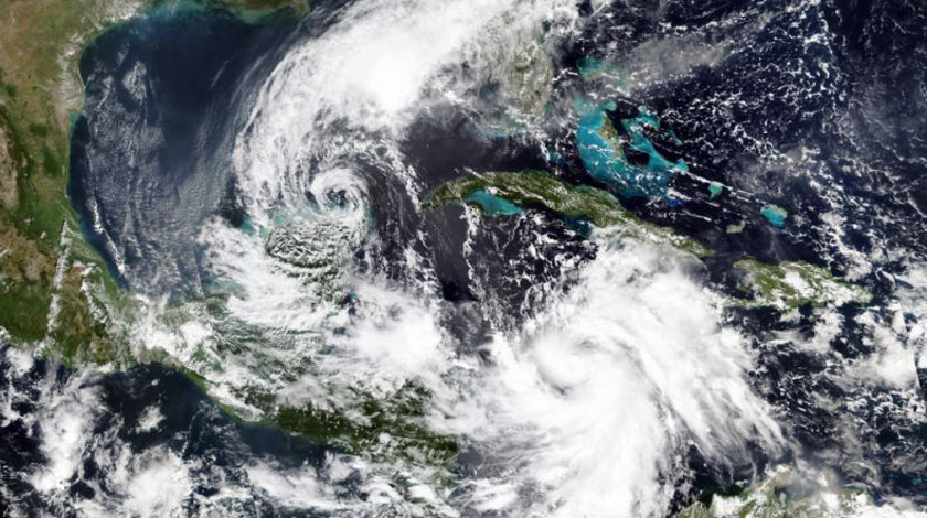 En esta imagen por satélite del 5 de octubre de 2020 proporcionada por NASA Worldview, Earth Observing System Data and Information System (EOSDIS), al tormenta tropical Gamma, a la izquierda, que castigó parte de México durante el fin de semana, y el huracán Delta, abajo a la derecha, que gana fuerza en un rumbo que lo llevará junto a las Islas Caimán el martes por la mañana. (NASA via AP)