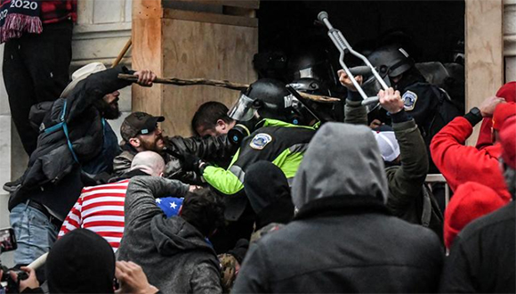 Partidarios de Donald Trump se enfrentan a la policía en la entrada oeste del Capitolio el 6 de enero de 2021. Foto: Reuters.