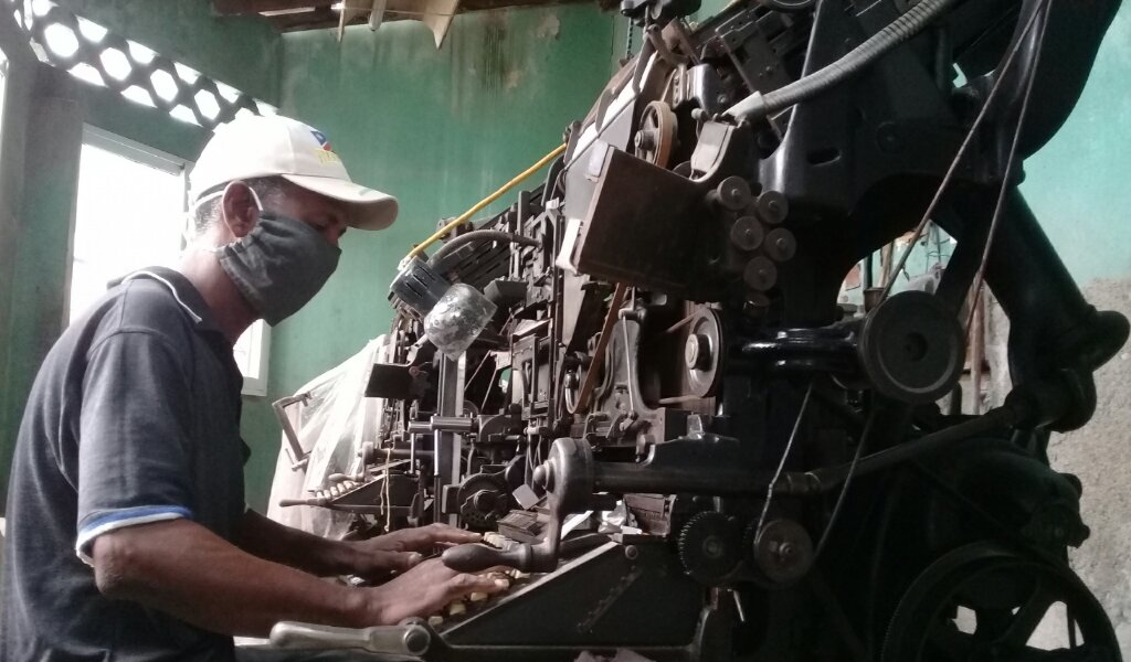 Reynaldo sentado frente a una de las viejas máquinas de linotipos //Foto Eliexer Pelaez Pacheco