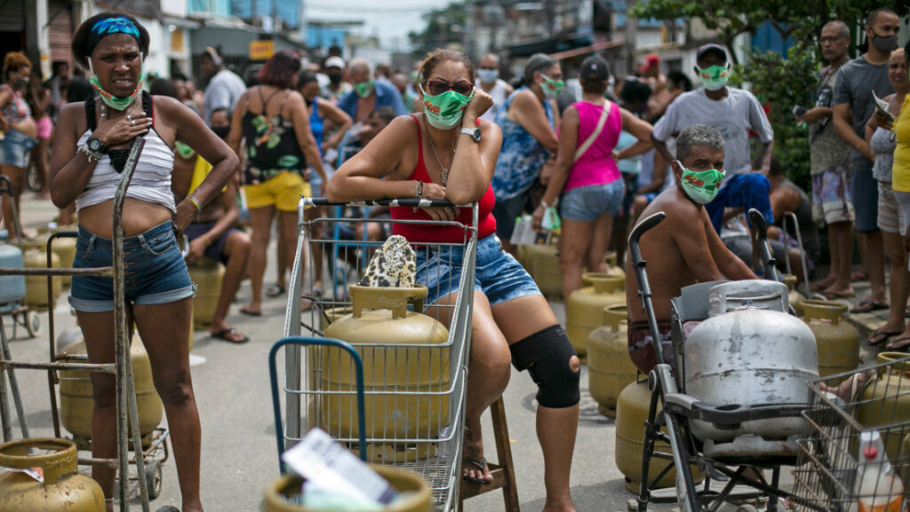Personas esperan surtir sus tanques de gas en una favela de Rio de Janeiro, Brasil, 12 de marzo de 2021Bruna Prado / AP