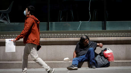 Un hombre con mascarilla pasa junto a un vagabundo sentado en una acera en Manhattan, Nueva York (EE.UU.), el 5 de mayo de 2020. // Foto
Mike Segar / Reuters