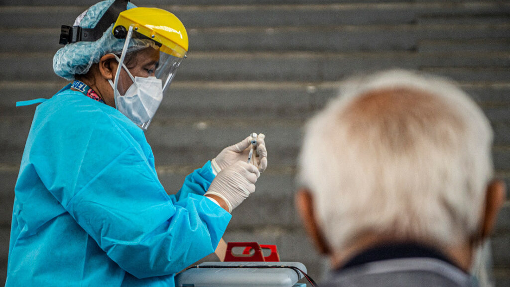 Un trabajador se prepara para inocular a un anciano contra el covid-19 en Lima, el 23 de abril de 2021Ernesto Benavides / AFP
