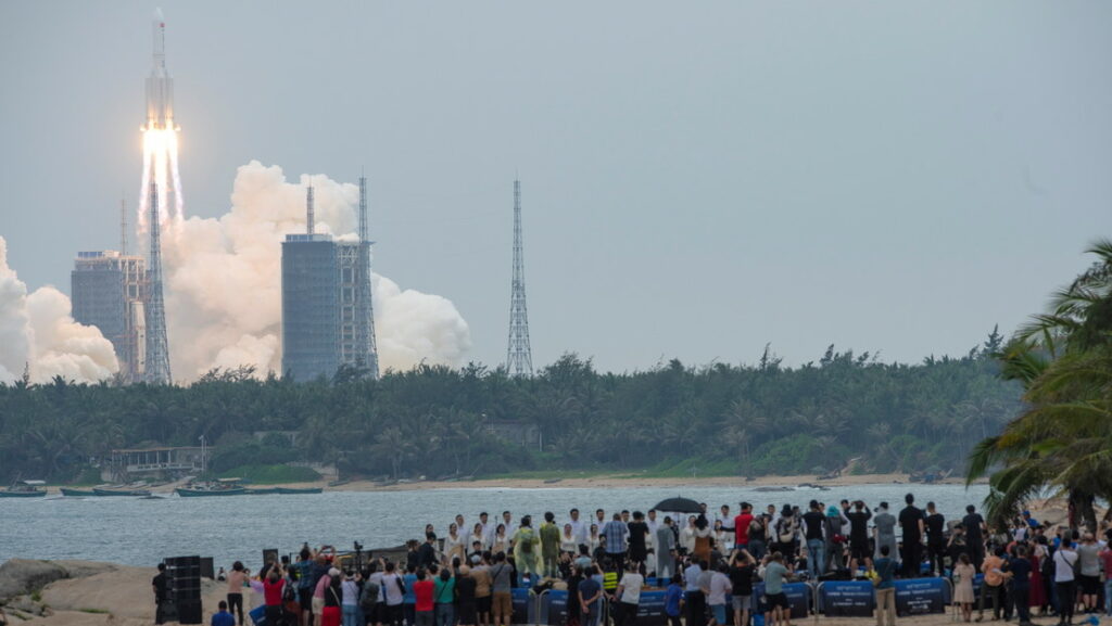 Decenas de personas observan desde una playa cómo el cohete Long March-5B Y2 despega del centro de lanzamiento espacial de Wenchang, en Hainan, China. 29 de abril de 2021.China Daily / Reuters