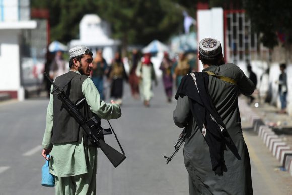 Dos talibanes vigilan la entrada del aeropuerto de Kabul. Foto: AFP