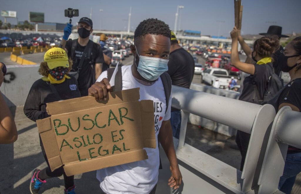 TIJUANA, BAJA CALIFORNIA, 21OCTUBRE2020.- Un grupo de migrantes de nacionalidad centroamericana realizaron una manifestación pacífica en la garita Internacional de San Ysidro con el objetivo de exigir el derecho que tienen a solicitar asilo humanitario. El gobierno de Estados Unidos cerró parcialmente la frontera debido a la pandemia del Covid-19 afectando a los migrantes que quedaron varados en Tijuana tras la suspensión de los trámites o solicitudes de asilo. FOTO: OMAR MARTÍNEZ /CUARTOSCURO.COM