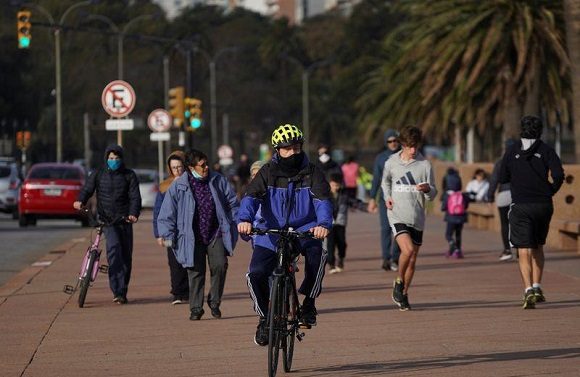 Varias personas pasean o montan bicicleta al aire libre en Uruguay. Foto: Mariana Greif / Reuters.