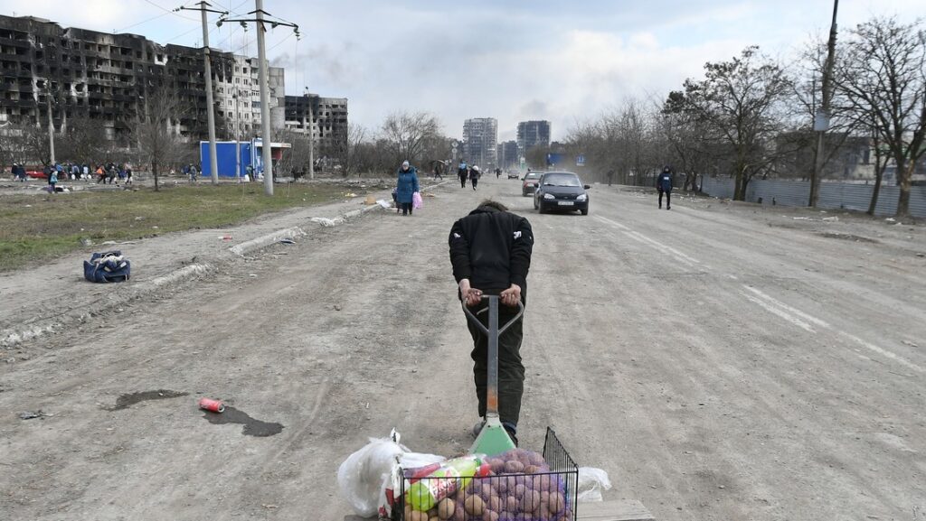 Un hombre tira de un carro de comida en una carretera de Mariúpol, Donbass, el 16 de marzo de 2022.Maxim Blinov / Sputnik
