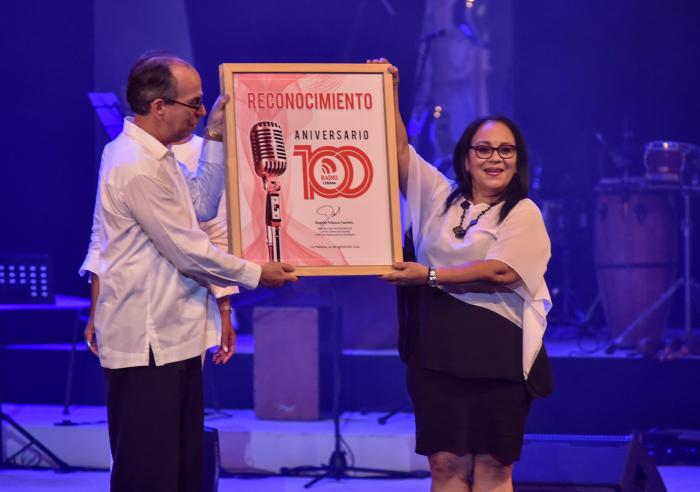 Rogelio Polanco Fuentes, miembro del secretariado del Comité Central del Partido y Jefe de su Departamento ideológico, hizo entrega de un reconocimiento a la Radio Cubana por su centenario, recibido por su directora general Yuzaima Cardona Villena // Foto: Ariel Cecilio Lemus