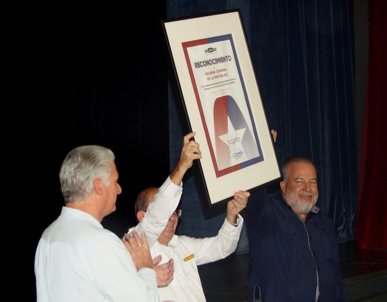 Miguel Díaz-Canel Bermúdez (I), Primer Secretario del Comité Central del Partido Comunista de Cuba y Presidente de la República y Manuel Marrero Cruz (D), Primer Ministro, entregan reconocimiento a Nelson Cordovés Reyes (C), Jefe de la Aduana General, en el acto central por el aniversario 60 de la Aduana Socialista, efectuada en la Sala Universal de las Fuerzas Armadas Revolucionarias (FAR), en La Habana, el 3 de febrero de 2023. ACN FOTO/Yury DÍAZ CABALLERO