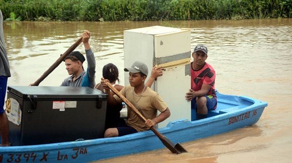 Pobladores rescatan sus bienes como consecuencia del desbordamiento del rio Yara, debido a la compleja situación hidrometeorológica que afecta a la provincia Granma, en la comunidad rural Las Caobas del municipio Yara, Cuba, el 10 de junio de 2023. ACN // Foto: Armando Ernesto CONTRERAS TAMAYO/ogm