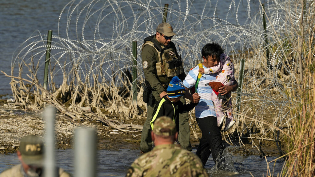 Migrantes son puestos bajo custodia por oficiales en la frontera entre Texas y México, el 3 de enero de 2024. // Foto: Eric Gay / AP 