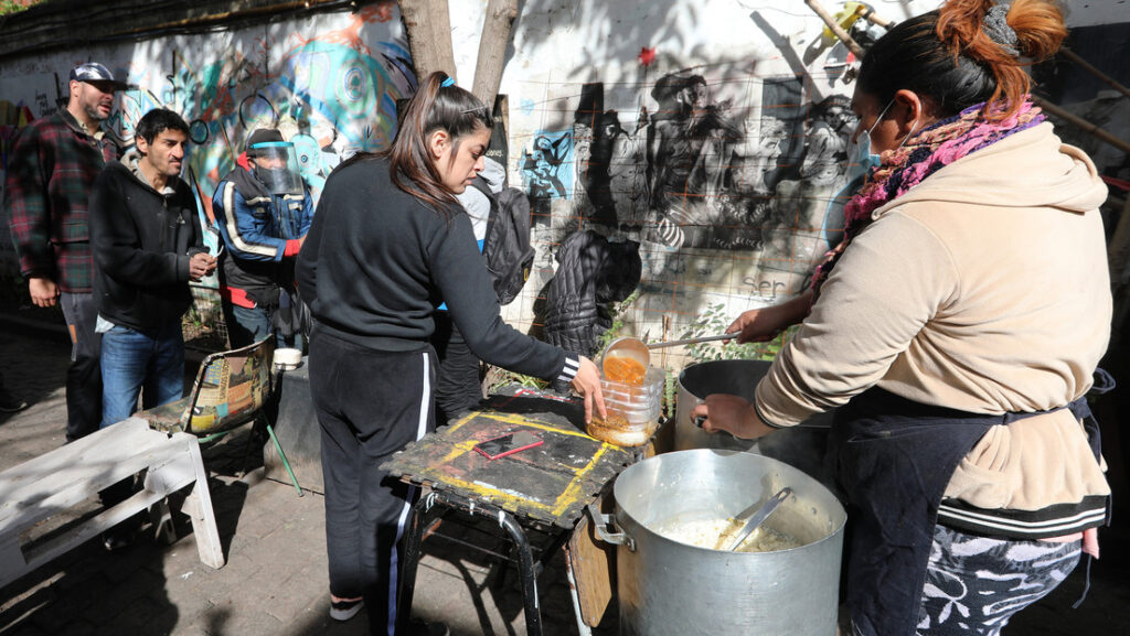 Una mujer sirve comida en un recipiente de plástico para entregar a personas carecientes, en Buenos Aires, Argentina, el 10 de agosto de 2022.Claudio Santisteban / Gettyimages.ru