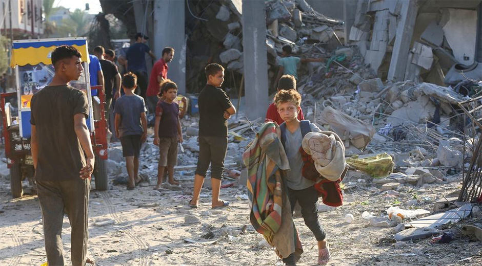 Un niño saca sus pertenencias de un edificio bombardeado en Gaza. Foto: UNRWA.