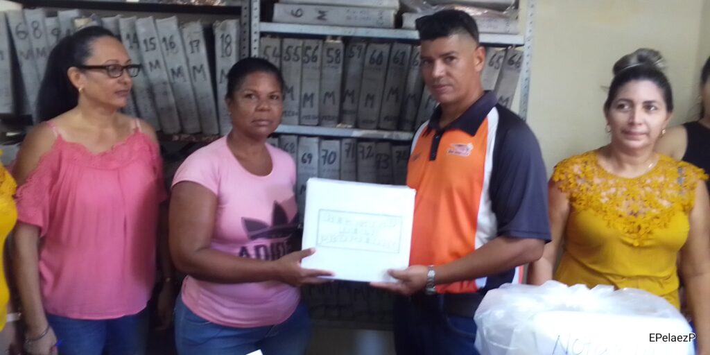 La maestra manzanillera Dailys Céspedes Aliaga recibe de manos del director de Justicia de Manzanillo la donación destinadas a sus familia del municipio Imías //Foto: Eliexer Pelaez Pacheco