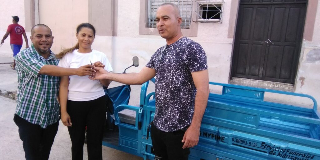 La administradora de la funeraria local y el Intendente de Manzanillo reciben la llave del triciclo donado // Foto: Eliexer Pelaez Pacheco