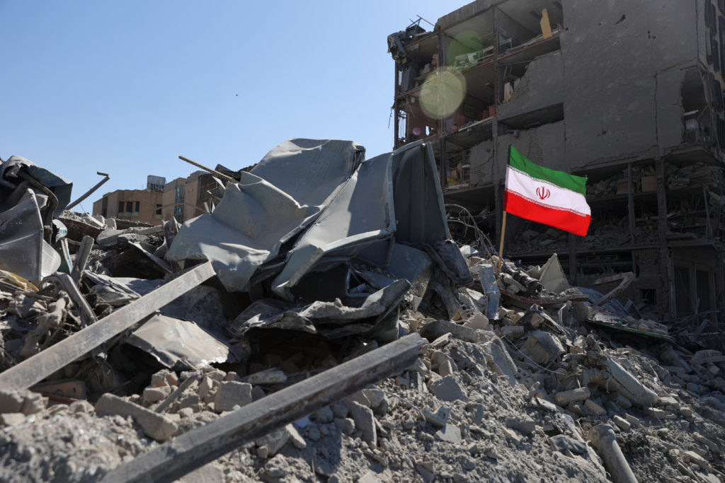 The national flag of Iran flies in the wind as debris lies scattered in the aftermath of an Israeli and U.S. strike on a police station, amid the U.S.-Israeli conflict with Iran, in Tehran, Iran, March 3, 2026. Majid Asgaripour/WANA (West Asia News Agency) via REUTERS ATTENTION EDITORS – THIS PICTURE WAS PROVIDED BY A THIRD PARTY